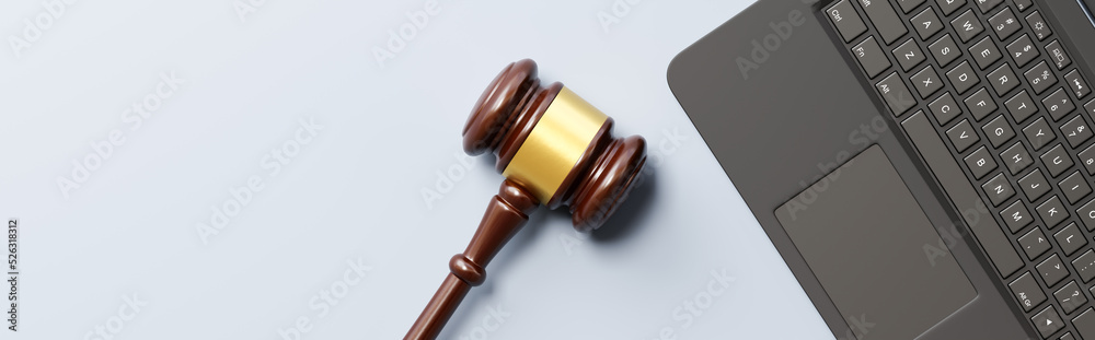 Judge's Gavel and Laptop Computer on Gray Background with Copy Space Judge's Gavel and Laptop Computer on Gray Background with Copy Space