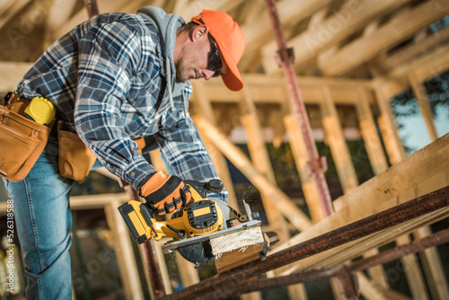 Carpenter Planing Wood Plank at the Construction Site