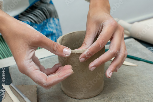 Hands of potter making clay cup. Pottery and clay classes