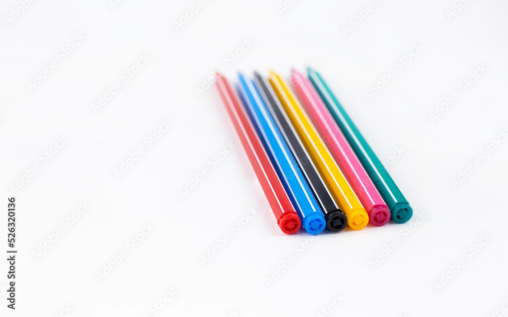Colored pens lie on a white background concept. Education. Background. School. Isolated Colored pens lie on a white background concept. Education. Background. School. Isolated