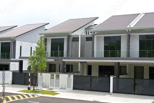 SELANGOR, MALAYSIA - JUNE 18, 2022: New double-story terrace house under construction in Malaysia. This house has a wide front porch and is fenced. Has basic facilities.
