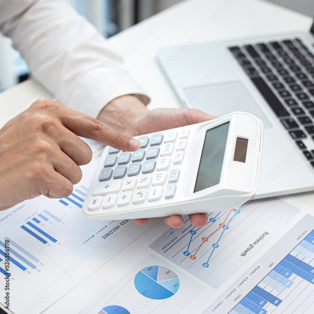 Businessman are calculating finances and analyzing market data with graphs and laptops at work, Business Financing Accounting Banking and tax system Concept. Businessman are calculating finances and analyzing market data with graphs and laptops at work, Business Financing Accounting Banking and tax system Concept.