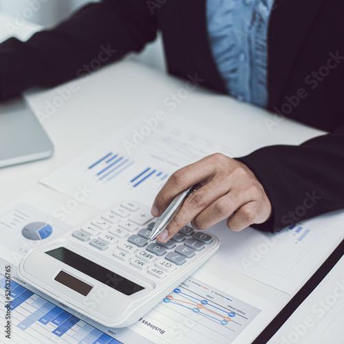 Businesswomen are calculating finances and analyzing market data with graphs and laptops at work, Business Financing Accounting Banking and tax system Concept.