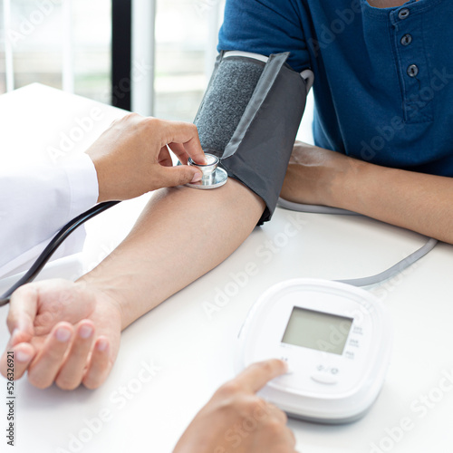 Female doctors use blood pressure monitors and stethoscope to measure pulse Diagnose the patient's disease in a modern hospital medical laboratory, Medical treatment and health care concept.