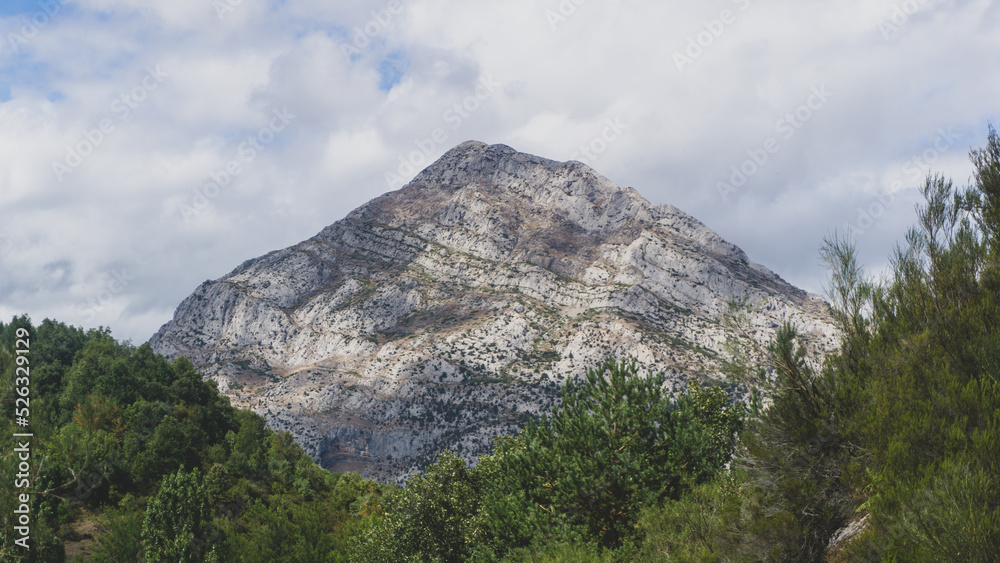 Fototapeta premium Enormous mountain peak with green vegetation below