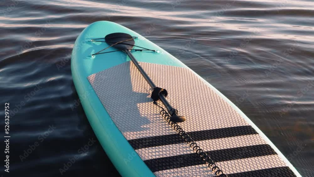 SUP board ready to sail on the water near the shore.