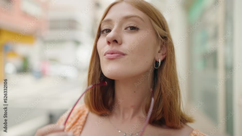 Young redhead woman smiling confident wearing glasses at street