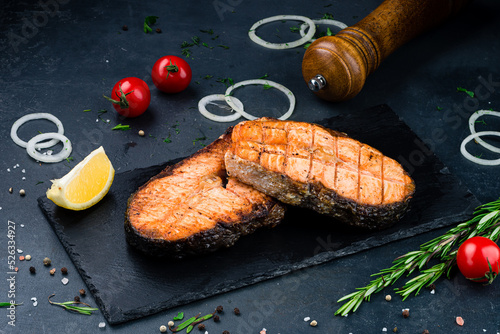 Grilled salmon fish on black stone background