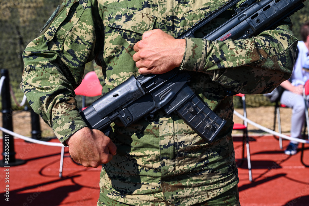 Soldier in uniform holding automatic riffle. Special forces with arms. 