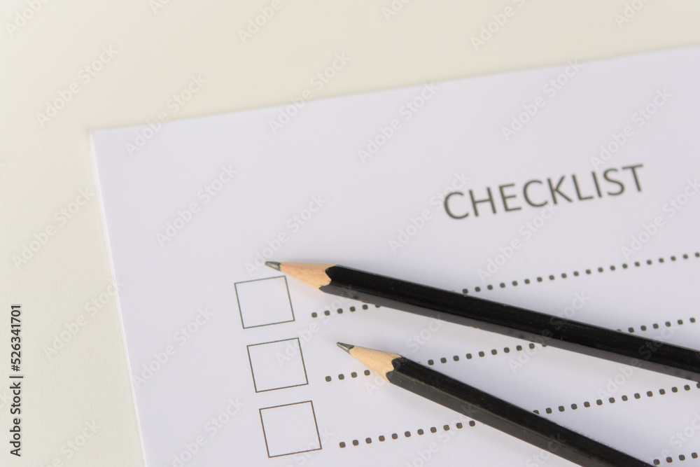 Checklist concept - checklist form paper and pencil on white table Checklist concept - checklist form paper and pencil on white table