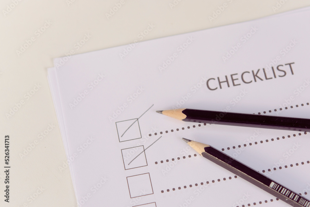 Checklist concept - checklist form paper and pencil on white table Checklist concept - checklist form paper and pencil on white table