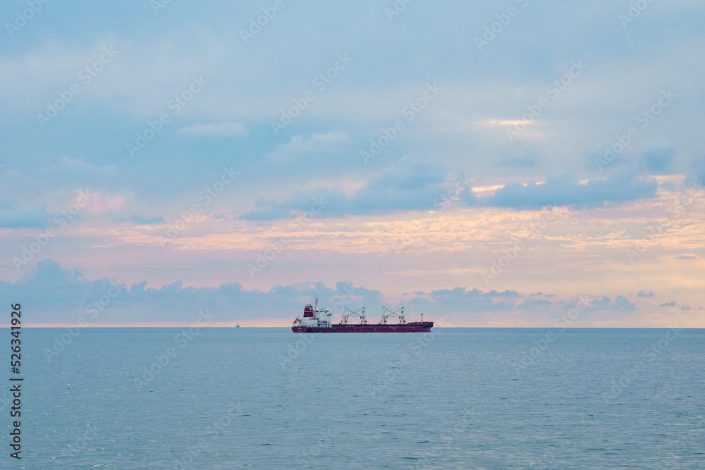 The ship sails in the Black Sea at sunset