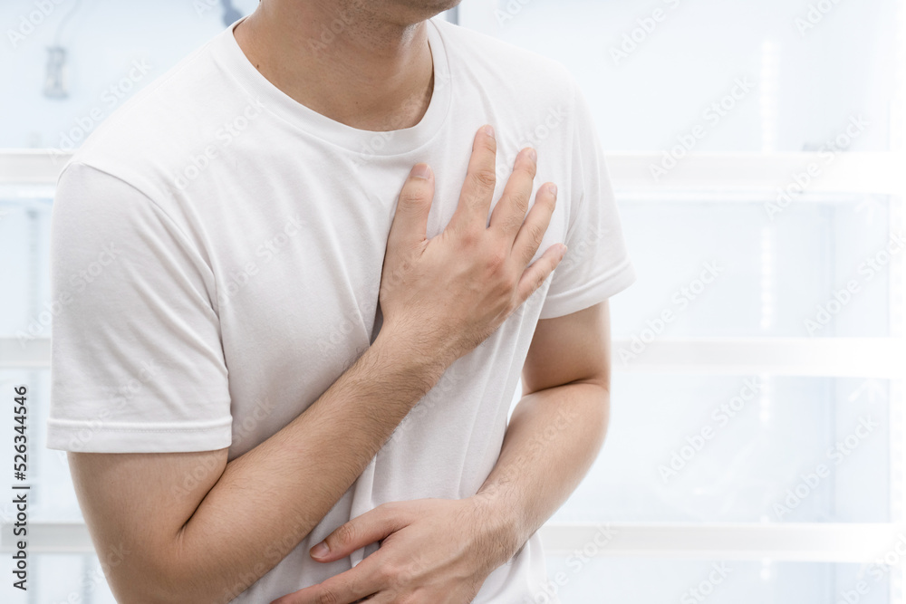 Man clutching his chest from acute pain.Heart attack symptom. Man clutching his chest from acute pain.Heart attack symptom.
