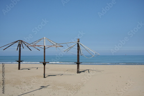 scheletri di ombrelloni in autunno sulla spiaggia