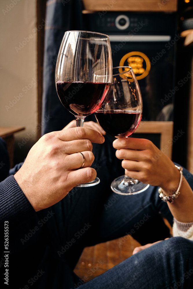 Glasses of red wine in the hands of a girl and a man who are resting. Celebrate and enjoy the moment. Tasting of alcoholic beverages. Romantic evening aperitif Glasses of red wine in the hands of a girl and a man who are resting. Celebrate and enjoy the moment. Tasting of alcoholic beverages. Romantic evening aperitif