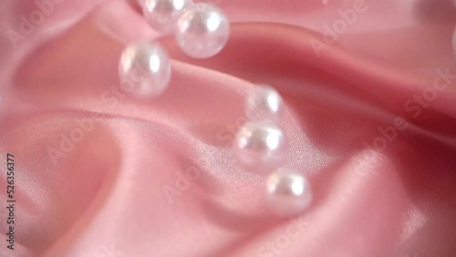Pearls fall on silk. Slow motion.