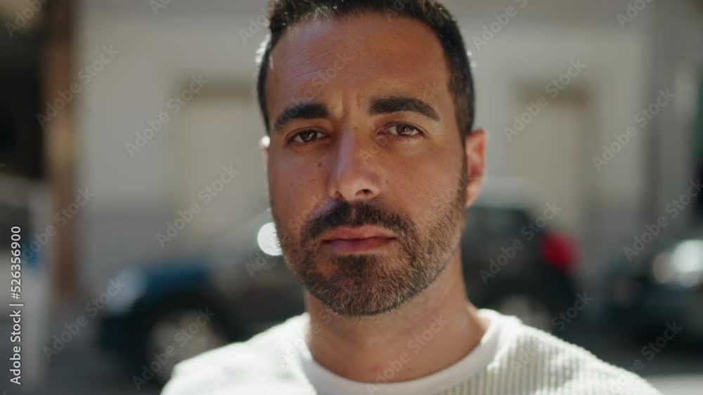 Young hispanic man with relaxed expression standing at street Young hispanic man with relaxed expression standing at street