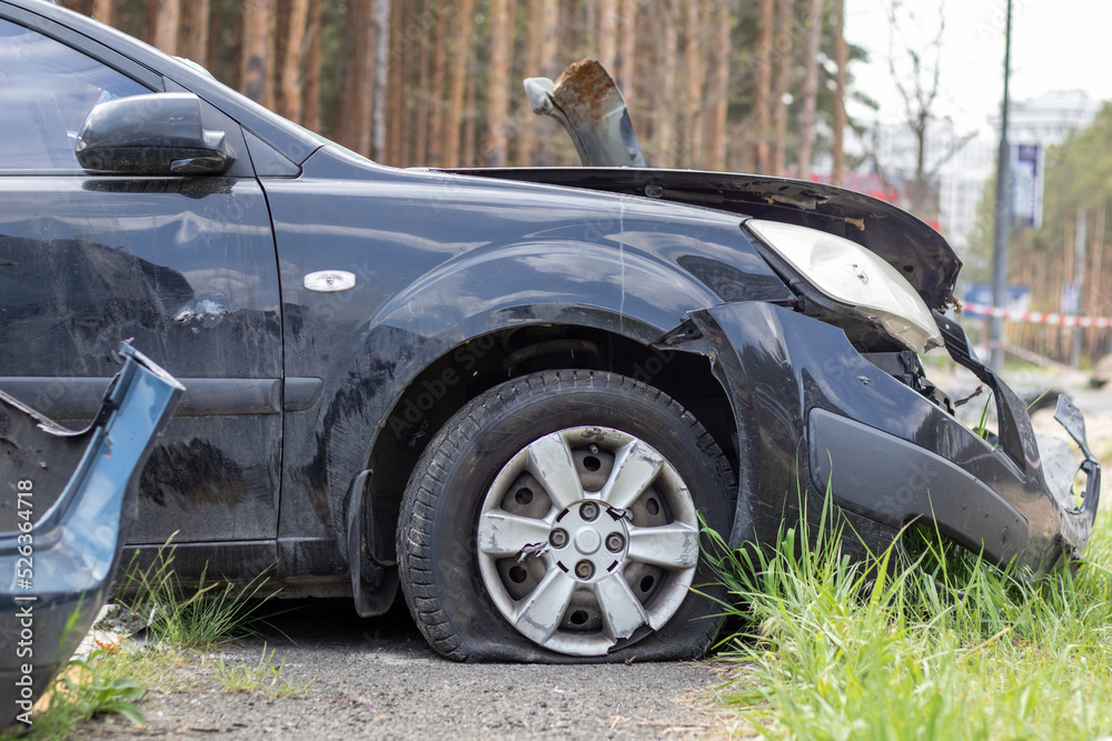Black car after a terrible accident on the side of the road. Frontal and side impact. Life insurance. An accident without the possibility of recovery. Side view. Damage after an accident. Black car after a terrible accident on the side of the road. Frontal and side impact. Life insurance. An accident without the possibility of recovery. Side view. Damage after an accident.