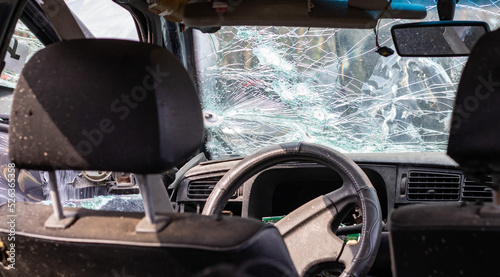 Damaged car window after an accident. Broken windshield as a result of an accident, inside view. Cabin interior details, view from the cab. Safe movement. Broken windshield. Glass crack and damage.