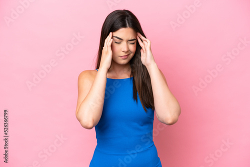 Young Brazilian woman isolated on pink background with headache