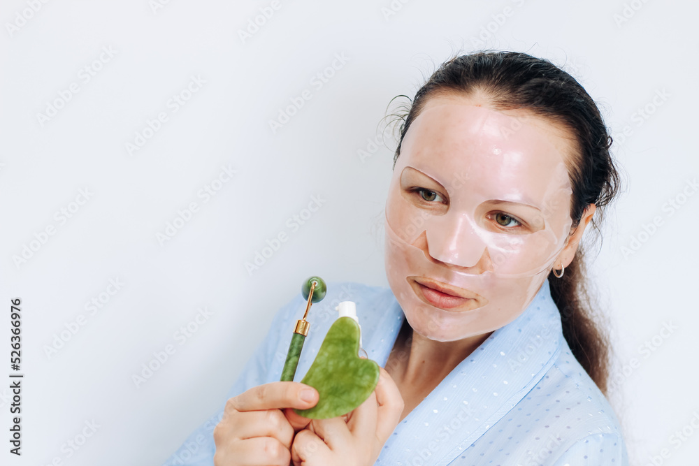 The girl makes a massage with a jade massager close-up, problem skin.