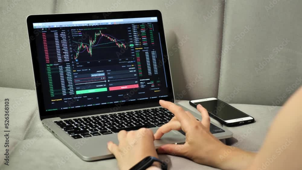 Laptop and phone to buy bitcoin on the Binance crypto exchange during the market crash. Trading, spot, staking. Workspace freelance flatlay