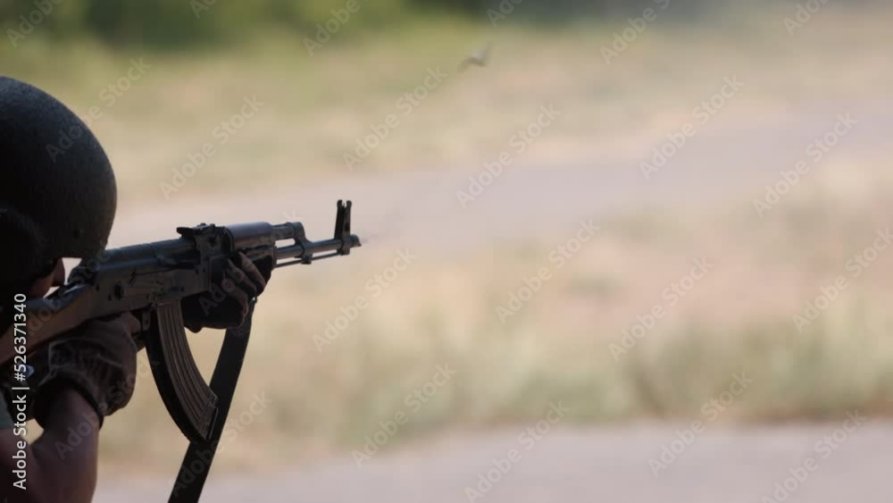 Military man in green uniform vest unloading gun with machine gun in hand, soldier lying on ground with gun, officer firing machine gun, Army gunner attacking, Army war concept. Military man in green uniform vest unloading gun with machine gun in hand, soldier lying on ground with gun, officer firing machine gun, Army gunner attacking, Army war concept.