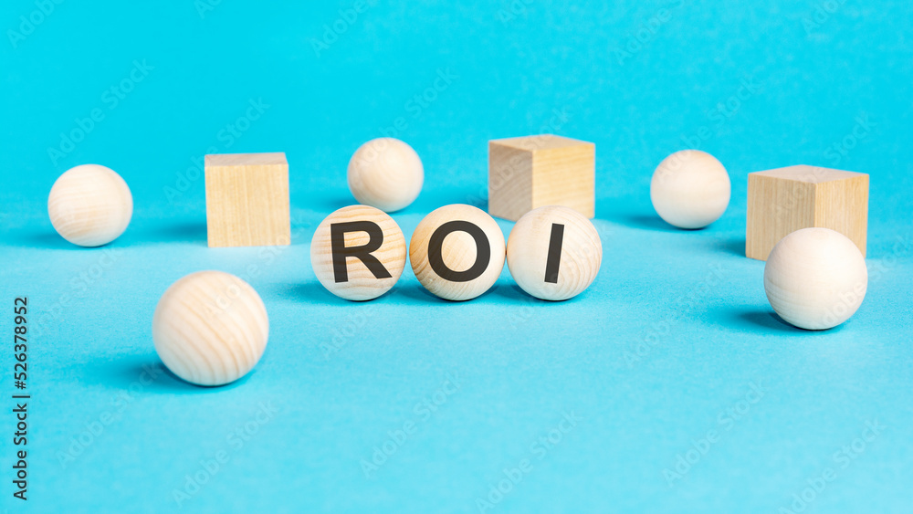 acronym roi on wooden balls, bright blue background acronym roi on wooden balls, bright blue background