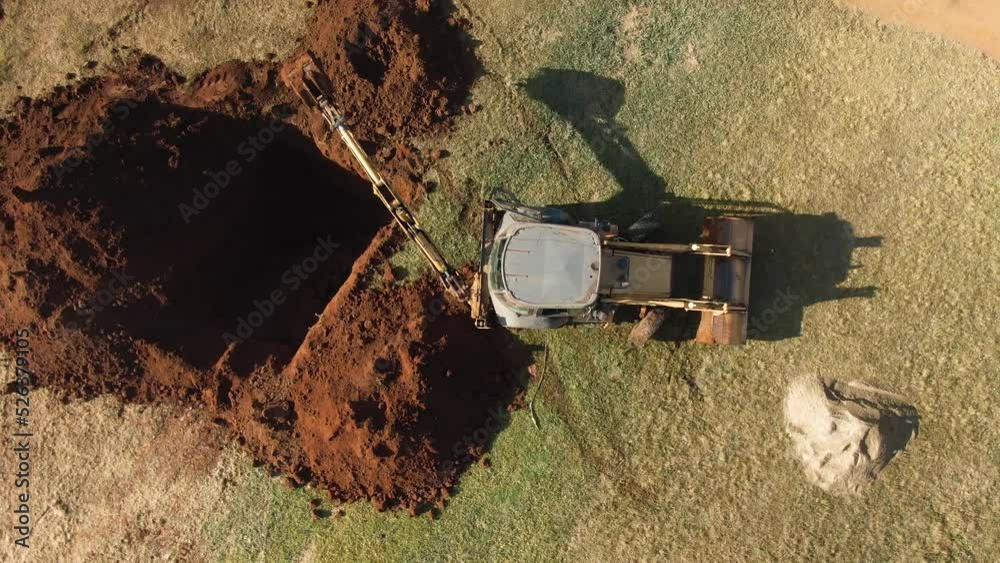 Drone view of an excavator digging a big hole