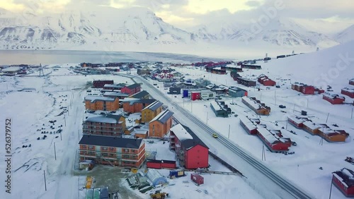 Aerial view of Longyearbyen, Svalbard in winter. With colorful houses, snow-capped mountains, with avalanche protection and fjord. Drone flight. High quality 4k footage