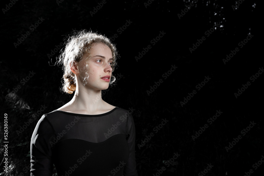 Portrait of a girl in backlight on a dark background Portrait of a girl in backlight on a dark background