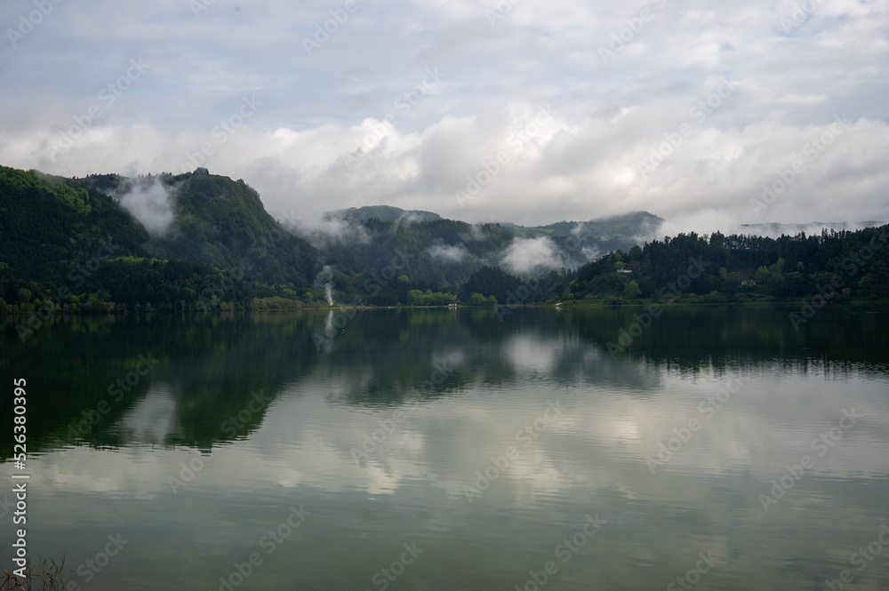 Clouds and hills reflecting in Lake Furnas