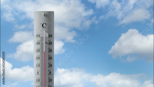 Thermometer with cloud timelaps in the background shows increasing temperature.