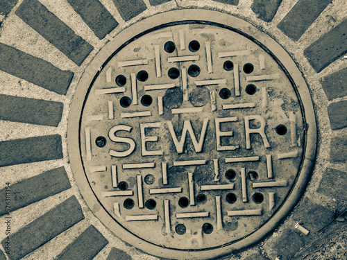 Grimy sewer manhole cover in city street