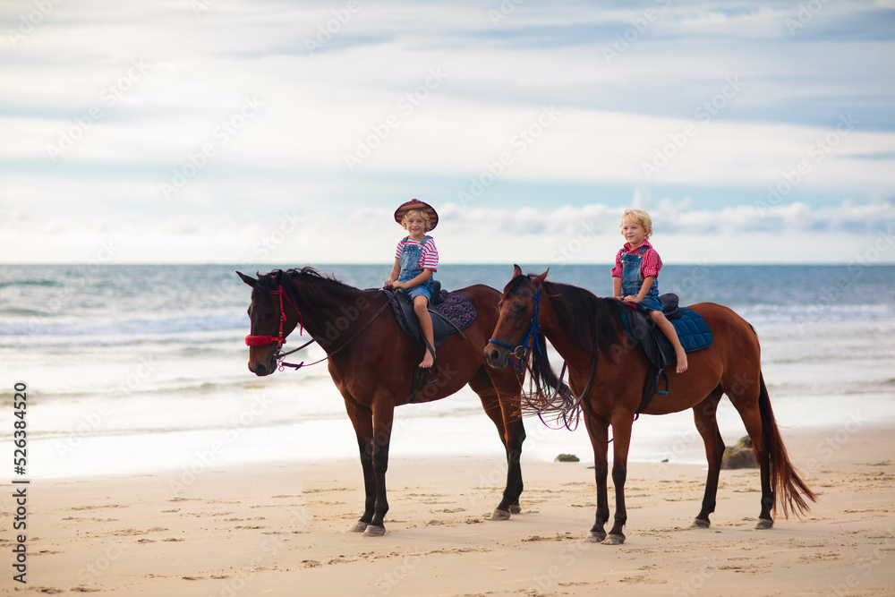 Kids riding horse on beach. Children ride horses. Kids riding horse on beach. Children ride horses.