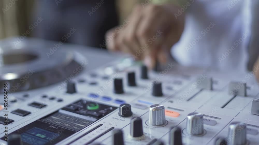 Mano de Dj con mixer blanco reproduciendo música 