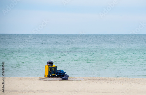 Fototapeta Naklejka Na Ścianę i Meble -  Yellow thermal bag of a food delivery man on the seashore. Fast delivery groceries and food orders from restaurants and cafes. Takeaway food