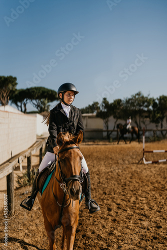 15-year-old warming up a brown horse in the equestrian arena © Samuel Perales