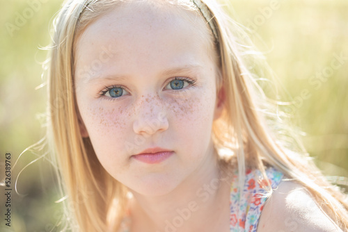 Vászonkép Beautiful little Caucasian girl with blond hair, blue eyes and freckles looking