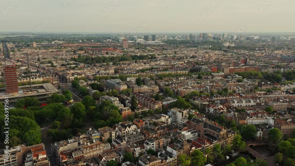 Top view of the Amsterdam canal between the streets with beautiful old traditional houses. Ships moored along the embankment, drone video. Amsterdam, Netherlands