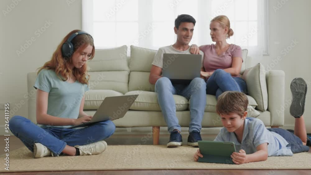 A parent and Children using a laptop, smartphone in the living room.