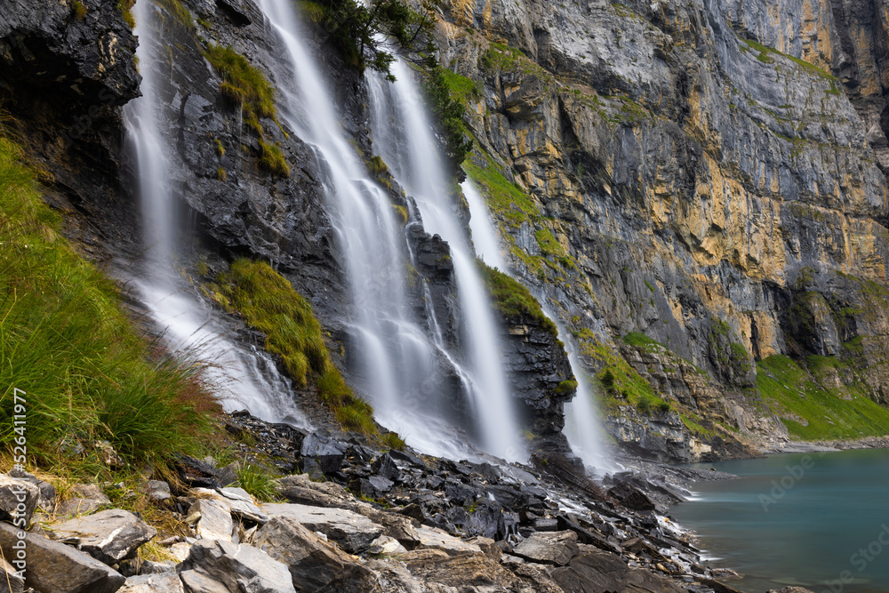 Naklejka premium Mystic waterfall at Lake Oeschinen in the Bernese Alps, Switzerland 
