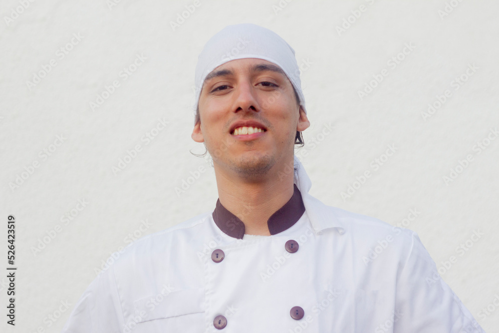 Young Chef smiles at camera on white background space for design Young Chef smiles at camera on white background space for design