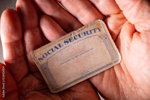 A U.S. Social Security card in the palm of a hand. photo