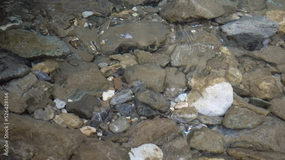 Thawed clean water in a mountain river with a rocky bottom. Thawed clean water in a mountain river with a rocky bottom.