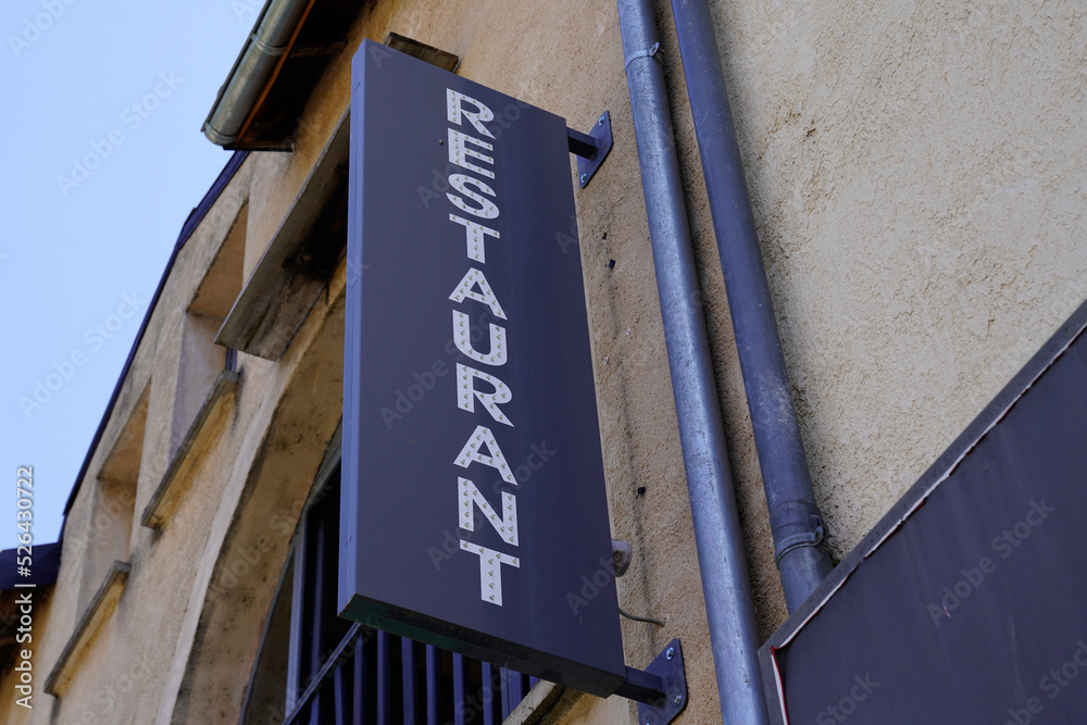 restaurant signboard text sign on wall facade entrance in city street restaurant signboard text sign on wall facade entrance in city street