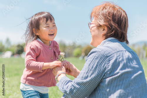 Photography おばあちゃんに花を渡す子供（幼児・笑顔）