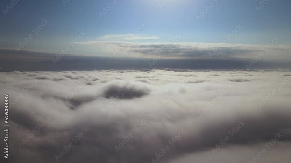 Aerial view from airplane window at high altitude of earth covered with puffy cumulus clouds forming before rainstorm Aerial view from airplane window at high altitude of earth covered with puffy cumulus clouds forming before rainstorm
