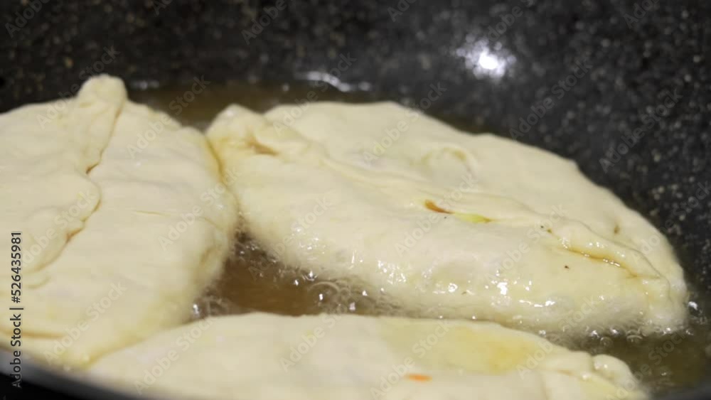 Woman chef prepares pies in boiling oil. Fried pies with stuffing. The