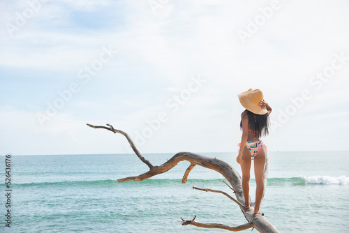 beautiful tanned girl in trendy bathing suit sunglasses stands on tree tropical island. Summer vacation, travel around the world, advertising swimwear new season